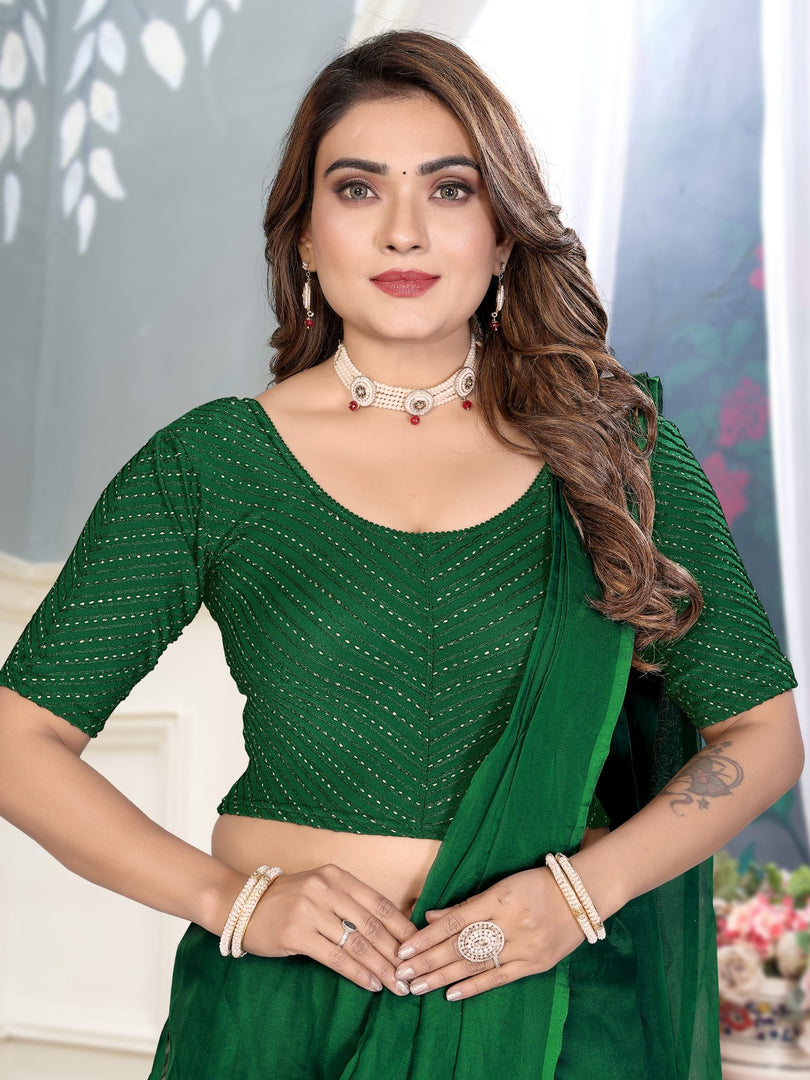 Woman wearing a green saree with a white blouse against a neutral background