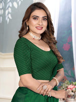 Load image into Gallery viewer, Woman wearing a green saree with a blurred background